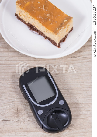Glucometer for measuring sugar level and sweet cheesecake. Nutrition during diabetes Glucometer for measuring sugar level and sweet cheesecake. Nutrition during diabetes 139515234