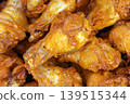Close-Up of Tender Grilled Hot and Spicy Chicken Drumettes Piled Together, Coated in a Glossy Chili Glaze with Glistening Sauce and Rich Golden-Orange Color 139515344