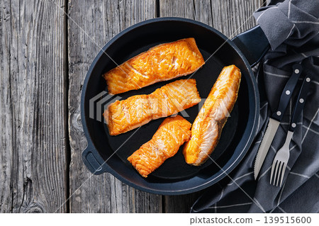 Pan-seared salmon fillets on a skillet, close-up Pan-seared salmon fillets on a skillet, close-up 139515600