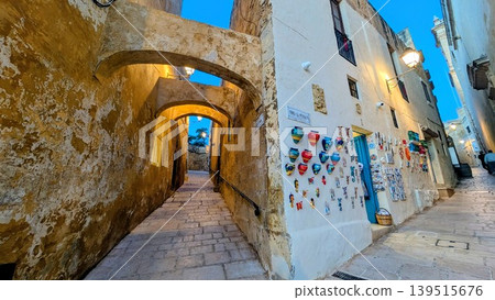 Evening view of narrow slopes with a souvenir shop at the corner in the old town in Gozo 139515676