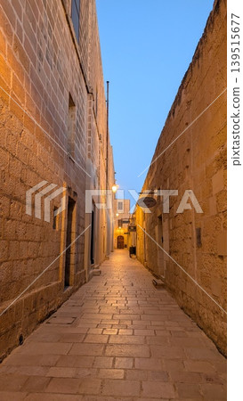 Narrow street between brick walls in the old town in the evening in Gozo 139515677