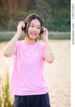 attractive asian woman healthy jogging exercise with headphones  in park outdoor 139515807