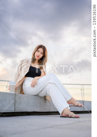 successful asian businesswoman holding a takeaway coffee cup outside of the office building successful asian businesswoman holding a takeaway coffee cup outside of the office building 139516196