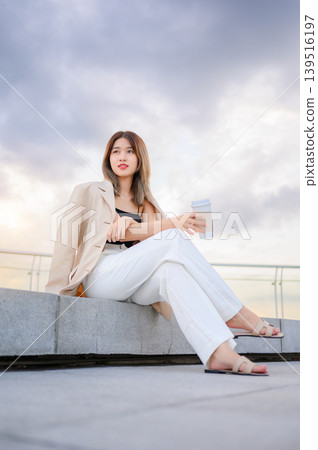 successful asian businesswoman holding a takeaway coffee cup outside of the office building successful asian businesswoman holding a takeaway coffee cup outside of the office building 139516197