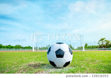 Soccer Ball on Grass Field in Front of Goal Post, Concept of Goal Setting and Sports Challenge Soccer Ball on Grass Field in Front of Goal Post, Concept of Goal Setting and Sports Challenge 139516353