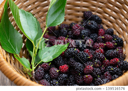 Delicious and healthy black mulberry (Morus nigra) fruits in a wicker basket. Delicious and healthy black mulberry (Morus nigra) fruits in a wicker basket. 139516576