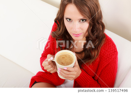 Girl red sweater holds mug with coffee Girl red sweater holds mug with coffee 139517496