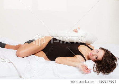 Sexy girl lazy woman with pillow on bed in bedroom Sexy girl lazy woman with pillow on bed in bedroom 139517591