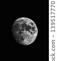 Detailed view of the moon in a vast, dark expanse of space. A crescent moon hangs in the blackness of the night sky. Close-up of the moon's surface, showcasing its craters and texture. 139517770