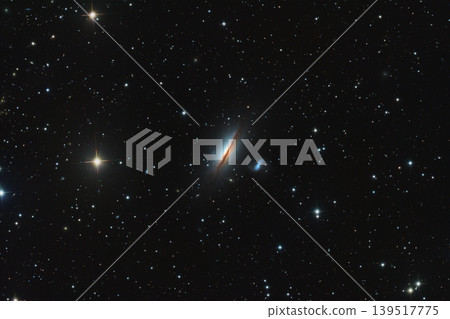 A astrophotography image of the edge-on lenticular galaxy NGC 5078 featuring a prominent dark dust lane and a nearby companion galaxy set against a dense field of distant stars. Telescope live. 139517775
