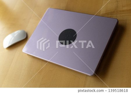 Closed Lavender Laptop and White Magic Mouse on Wooden Desk Closed Lavender Laptop and White Magic Mouse on Wooden Desk 139518618