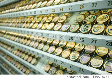 Collection of decorative round hand creams tins with intricate designs arranged neatly on shelves, showcasing various colors and patterns in a well-organized display Collection of decorative round hand creams tins with intricate designs arranged neatly on shelves, showcasing various colors and patterns in a well-organized display 139518735