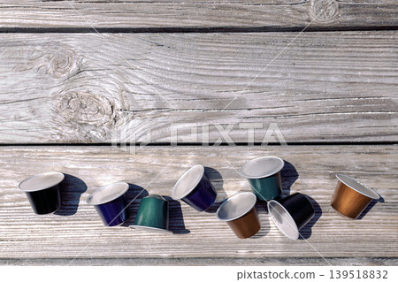 Multicolo red coffee capsules are scattered on the light wooden surfac Multicolo red coffee capsules are scattered on the light wooden surfac 139518832