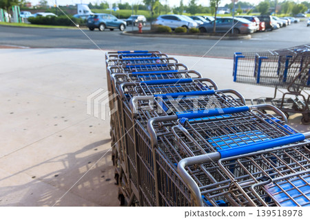Many shopping carts parked outside store near parking lot Many shopping carts parked outside store near parking lot 139518978