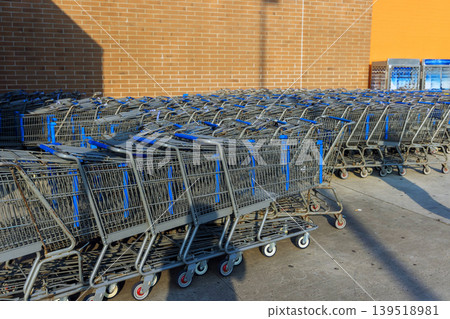 Shopping carts lined up outside store in daylight near brick wall Shopping carts lined up outside store in daylight near brick wall 139518981