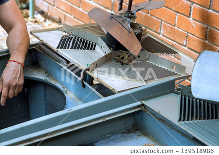 Repair work on an outdoor cooling unit in residential area Repair work on an outdoor cooling unit in residential area 139518986