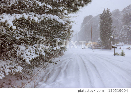 Snow covers quiet road in rural area during winter storm in early morning hours 139519004