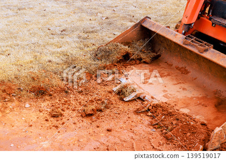 Construction equipment removes dirt grass in residential area work hours Construction equipment removes dirt grass in residential area work hours 139519017