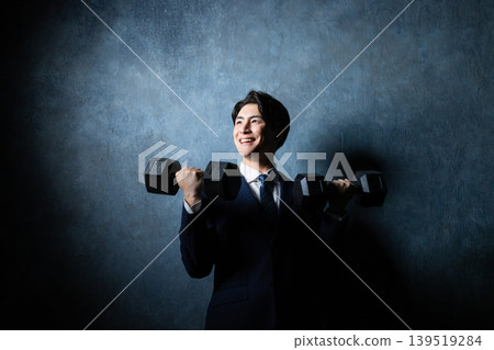 A businessman with a dumbbell A businessman with a dumbbell 139519284
