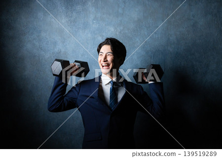 A businessman with a dumbbell A businessman with a dumbbell 139519289
