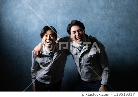 A man in work clothes with his arms crossed A man in work clothes with his arms crossed 139519337
