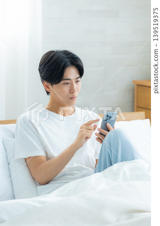 清晨,一個男人憂心忡忡地看著他的智慧型手機。 清晨,一個男人憂心忡忡地看著他的智慧型手機。 139519375