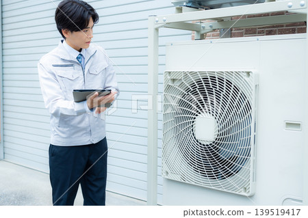 Workers inspecting air conditioners Workers inspecting air conditioners 139519417