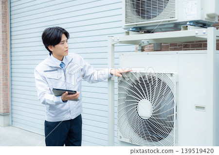 檢查空調的工人 檢查空調的工人 139519420