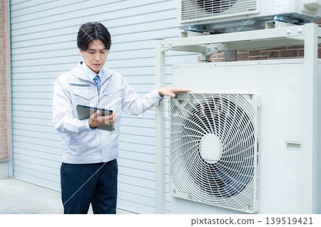 Workers inspecting air conditioners 139519421
