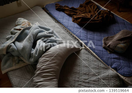 昏暗的房間裡隨意地放著一個枕頭和一條毯子。被褥陳舊,整體感覺很不舒適。 昏暗的房間裡隨意地放著一個枕頭和一條毯子。被褥陳舊,整體感覺很不舒適。 139519664