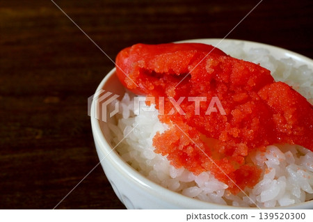 White rice and cod roe served in a bowl in the background of the table. White rice and cod roe served in a bowl in the background of the table. 139520300