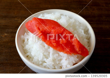 White rice and cod roe served in a bowl in the background of the table. 139520305