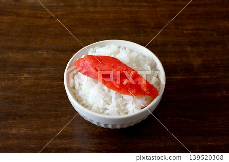 White rice and cod roe served in a bowl in the background of the table. White rice and cod roe served in a bowl in the background of the table. 139520308