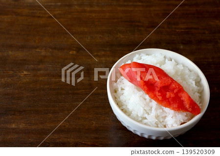 White rice and cod roe served in a bowl in the background of the table. White rice and cod roe served in a bowl in the background of the table. 139520309