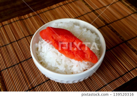 White rice and cod roe served in a bowl in the background of the table. White rice and cod roe served in a bowl in the background of the table. 139520316