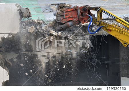 Construction site: Commercial building being demolished by heavy machinery. Construction site: Commercial building being demolished by heavy machinery. 139520560