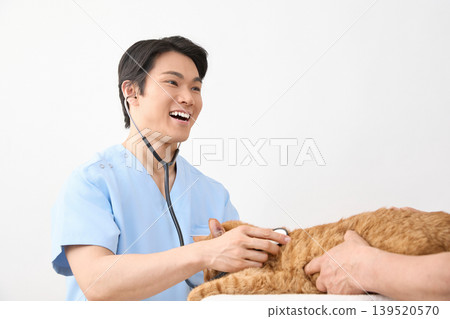 一位男獸醫在給貓看病時面帶微笑。 （動物醫療照護圖片） 139520570