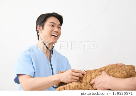 一位男獸醫在給貓看病時面帶微笑。 （動物醫療照護圖片） 139520571