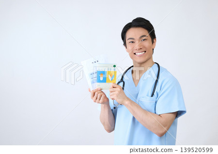 一位微笑的男性醫護人員手持用藥記錄簿,照片背景為白色。 一位微笑的男性醫護人員手持用藥記錄簿,照片背景為白色。 139520599