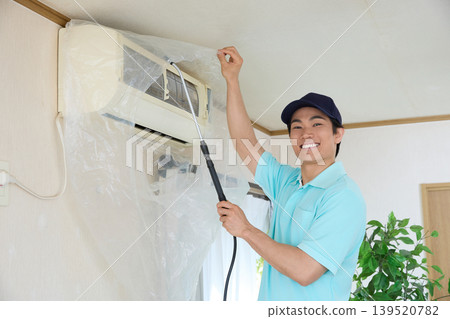 Smiling air conditioner cleaning staff (indoor work) Smiling air conditioner cleaning staff (indoor work) 139520782