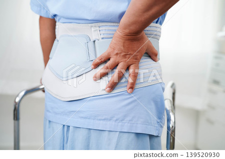 Asian senior pain back wearing elastic support belt with walker. Asian senior pain back wearing elastic support belt with walker. 139520930