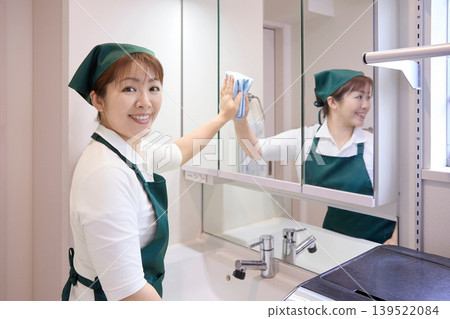 House cleaning staff cleaning the bathroom mirror House cleaning staff cleaning the bathroom mirror 139522084