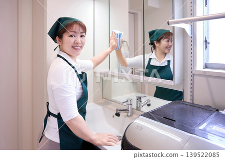 House cleaning staff cleaning the bathroom mirror 139522085