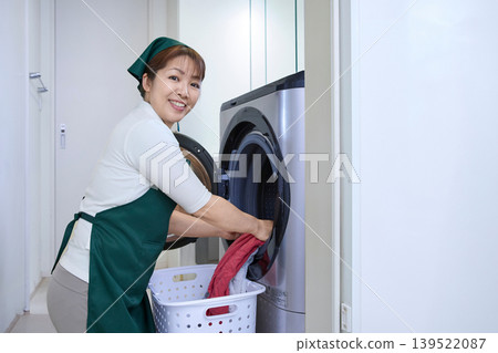 Housekeeping staff taking out the laundry Housekeeping staff taking out the laundry 139522087