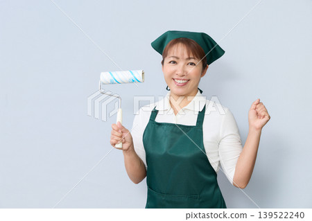 一位面帶微笑的家事清潔人員手持清潔滾筒。 一位面帶微笑的家事清潔人員手持清潔滾筒。 139522240