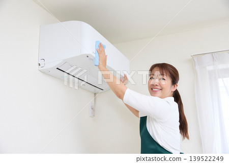 House cleaning staff cleaning air conditioners House cleaning staff cleaning air conditioners 139522249