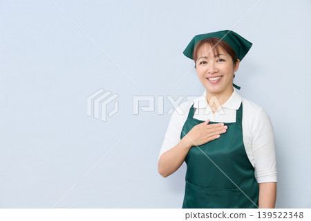 A house cleaning staff member places their hand on their chest. 139522348