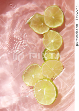 Fresh green lime slices floating in clear water with ripples texture. 139522550