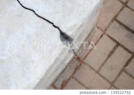 Cracked concrete block damage on urban sidewalk pavement 139522792