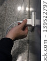 Hand plugging charger into wall socket 139522797